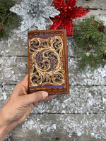 Hand-carved leather field notes cover with Western floral and feather design, purple and turquoise accents, handmade by Cherokee Rose Custom Leather.