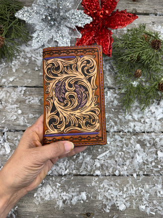 Hand-carved leather field notes cover with Western floral and feather design, purple and turquoise accents, handmade by Cherokee Rose Custom Leather.