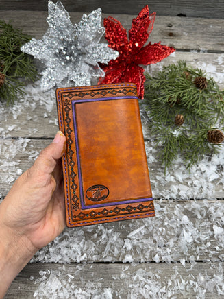 Hand-carved leather field notes cover with Western floral and feather design, purple and turquoise accents, handmade by Cherokee Rose Custom Leather.