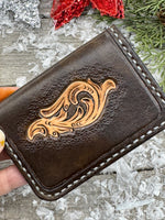 Hand-carved chocolate brown leather card wallet with floral scroll design and gray oil-tanned interior, handmade by Cherokee Rose Custom Leather.