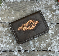 Hand-carved chocolate brown leather card wallet with floral scroll design and gray oil-tanned interior, handmade by Cherokee Rose Custom Leather.