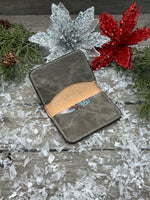 Hand-carved chocolate brown leather card wallet with floral scroll design and gray oil-tanned interior, handmade by Cherokee Rose Custom Leather.