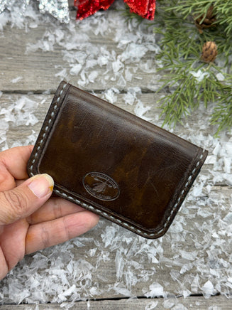 Hand-carved chocolate brown leather card wallet with floral scroll design and gray oil-tanned interior, handmade by Cherokee Rose Custom Leather.