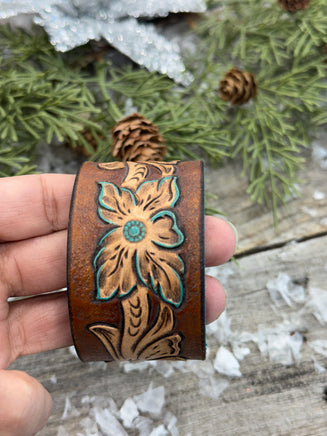 Hand-carved leather cuff bracelet with turquoise flower and floral scrollwork, silver snaps, turquoise suede back, handmade by Cherokee Rose Custom Leather in Texas.