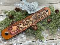 Hand-carved leather cuff bracelet with pink flower accent, gunmetal snaps, and brown suede lining, handmade by Cherokee Rose Custom Leather in Texas.