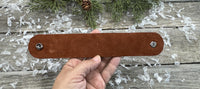 Hand-carved leather cuff bracelet with pink flower accent, gunmetal snaps, and brown suede lining, handmade by Cherokee Rose Custom Leather in Texas.