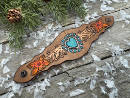 Hand-carved leather cuff bracelet with turquoise heart, orange flowers, and antique copper snaps, handmade by Cherokee Rose Custom Leather in East Texas.
