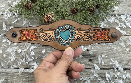 Hand-carved leather cuff bracelet with turquoise heart, orange flowers, and antique copper snaps, handmade by Cherokee Rose Custom Leather in East Texas.