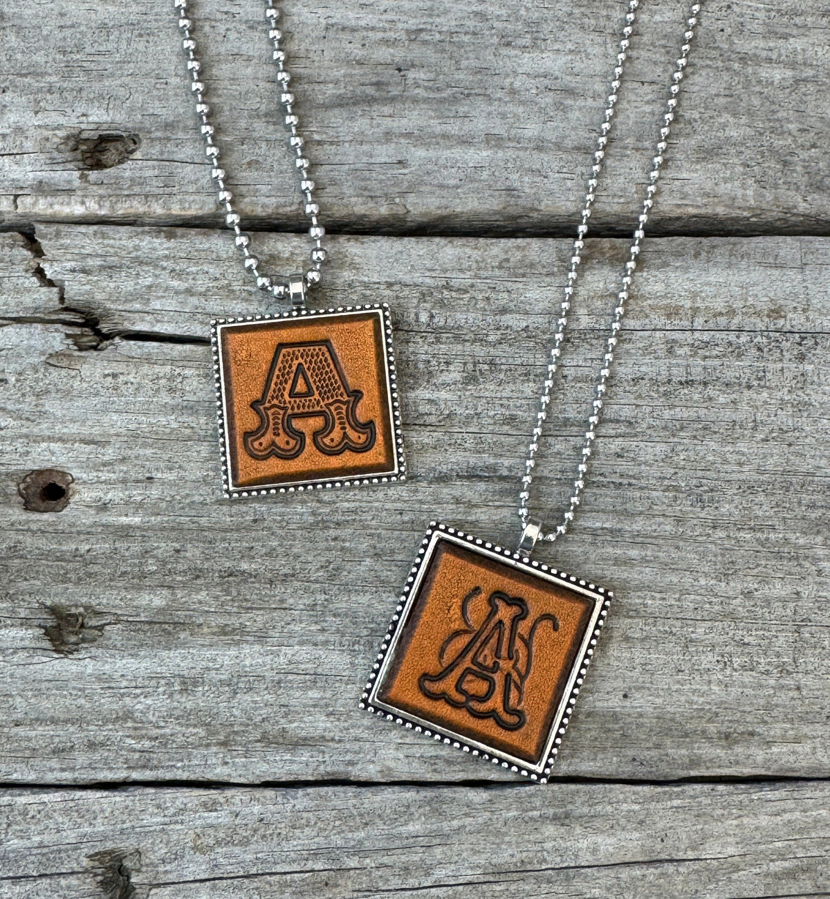 Letter A leather initial necklaces in Western Block and Floral Script fonts on silver ball chains