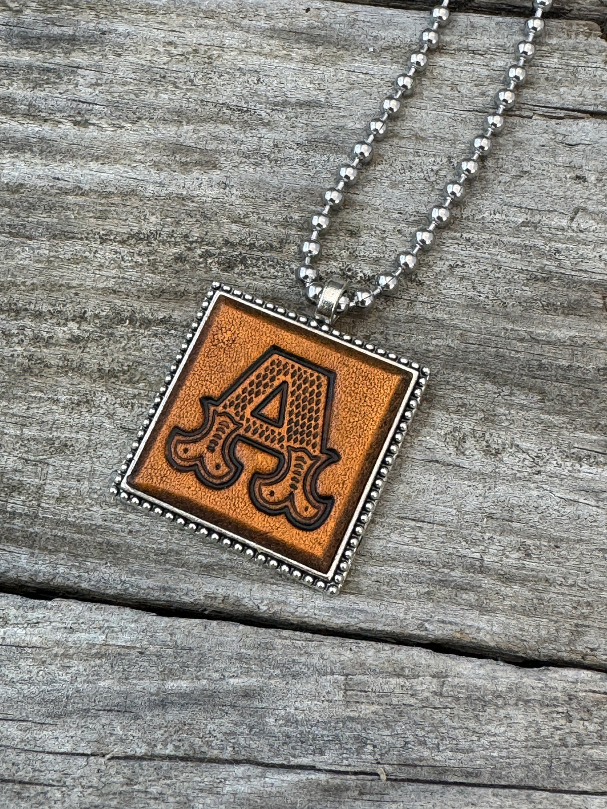 Western Block letter A hand-stamped leather pendant necklace in a silver-tone square frame
