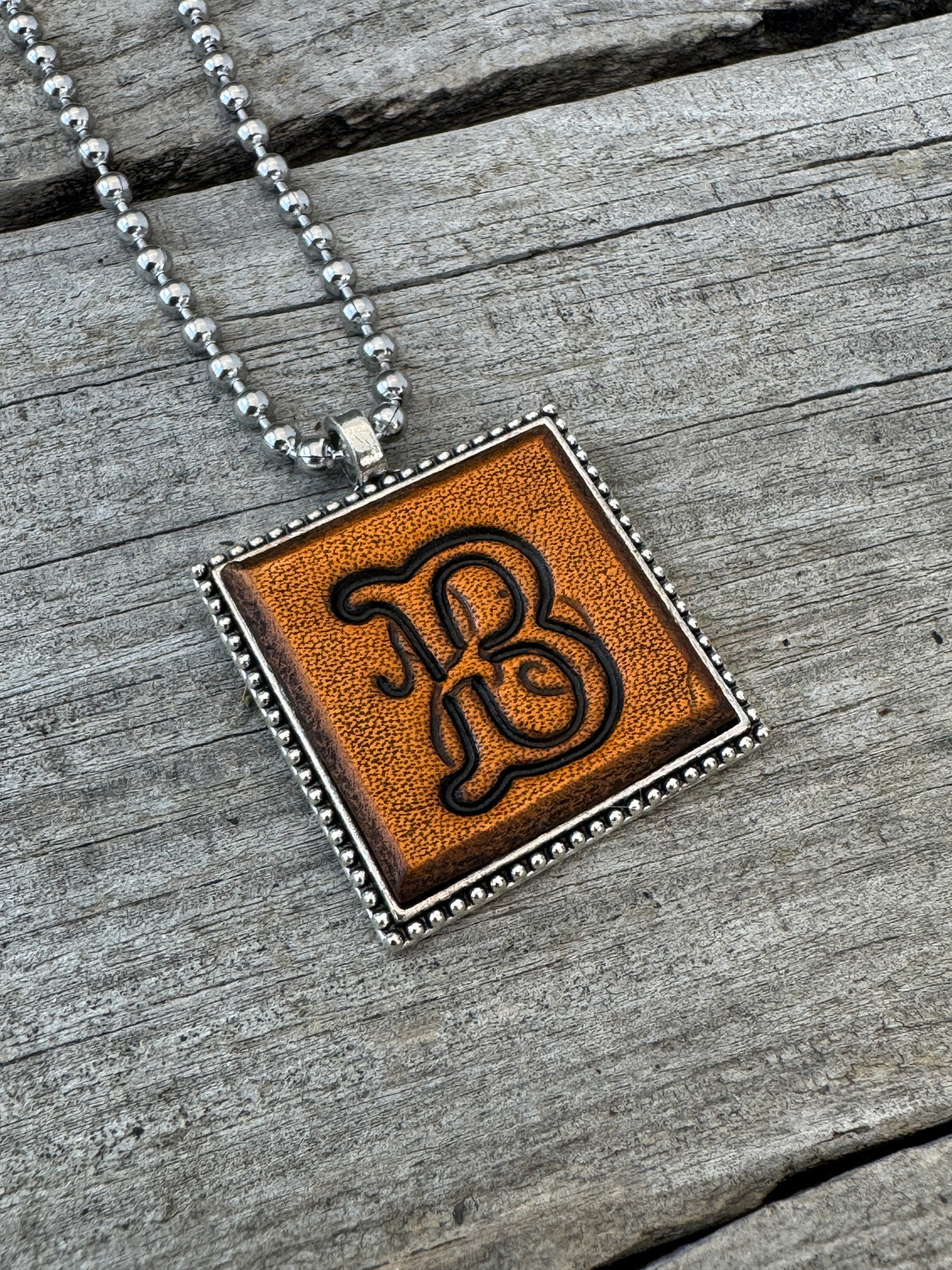 Floral Script letter B hand-stamped leather pendant necklace in a silver-tone square frame