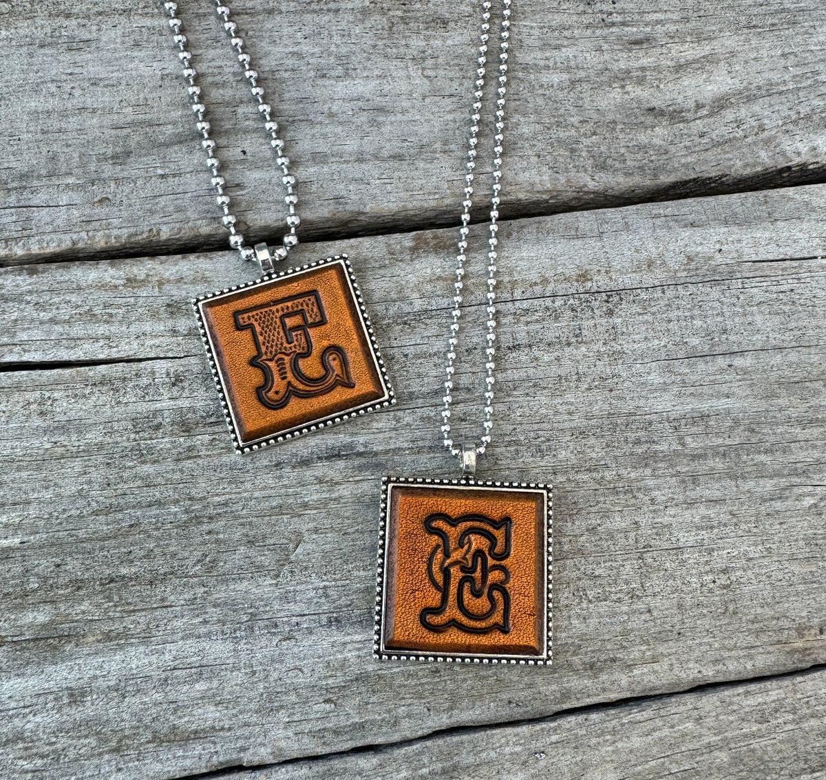 Letter E leather initial necklaces in Western Block and Floral Script fonts on silver ball chains