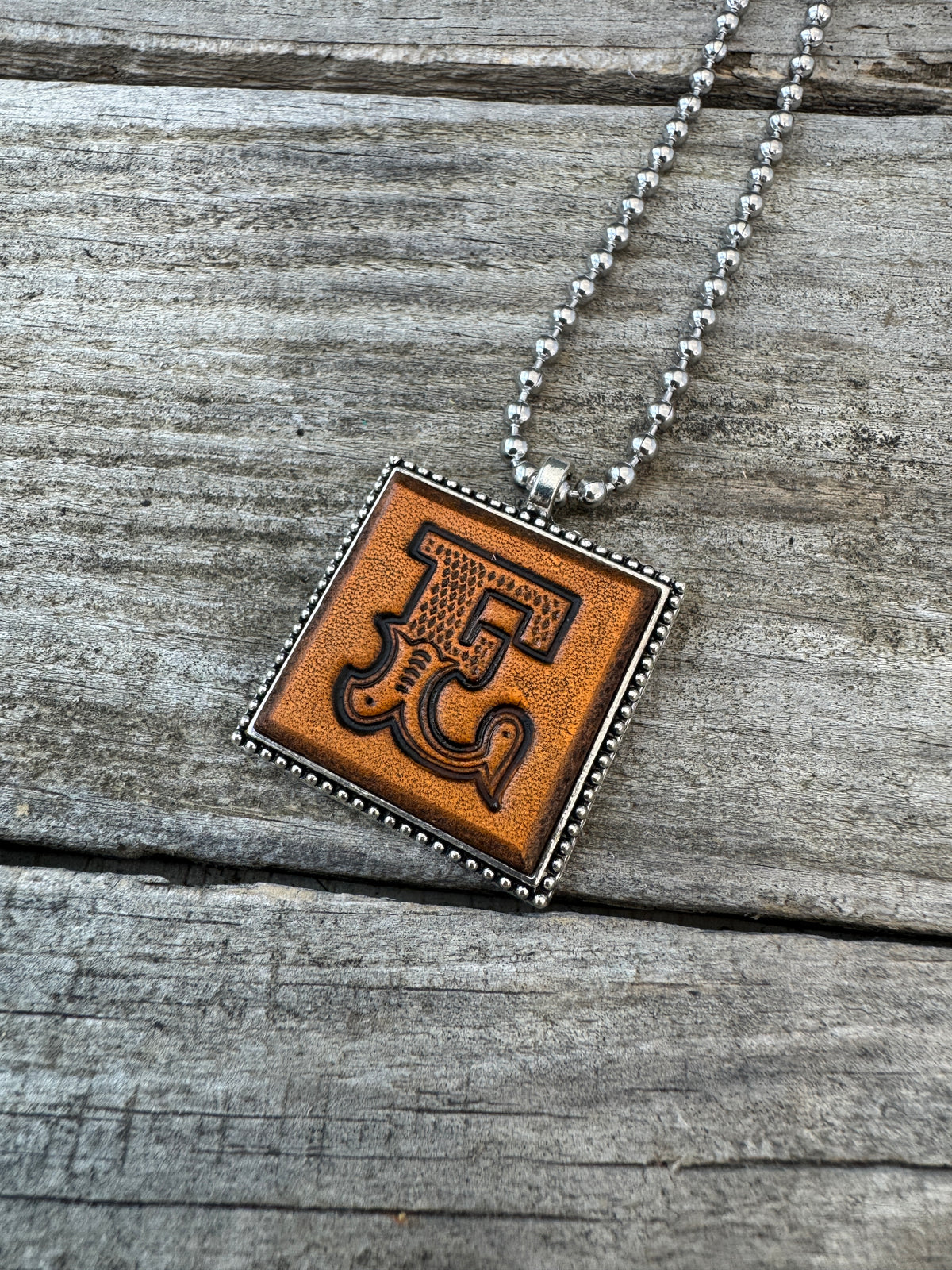 Western Block letter E hand-stamped leather pendant necklace in a silver-tone square frame
