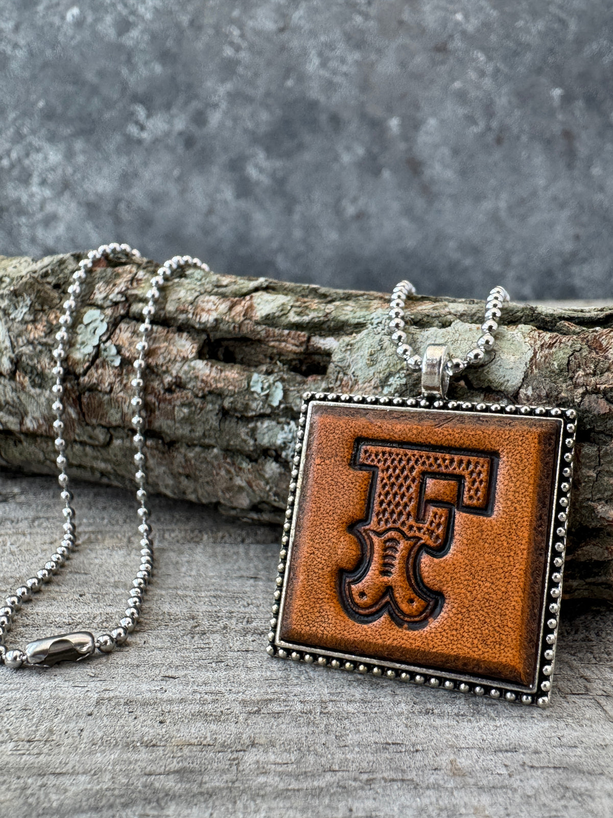 Western Block letter F leather initial necklace styled on rustic wood with a silver ball chain