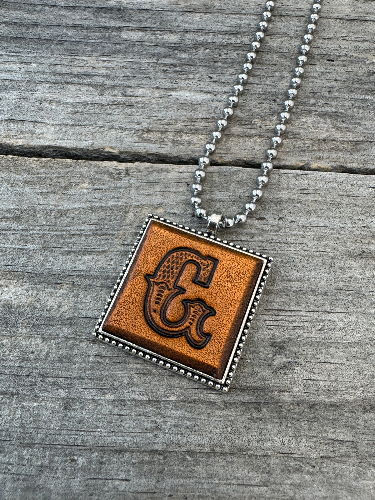 Western Block letter G hand-stamped leather pendant necklace in a silver-tone square frame