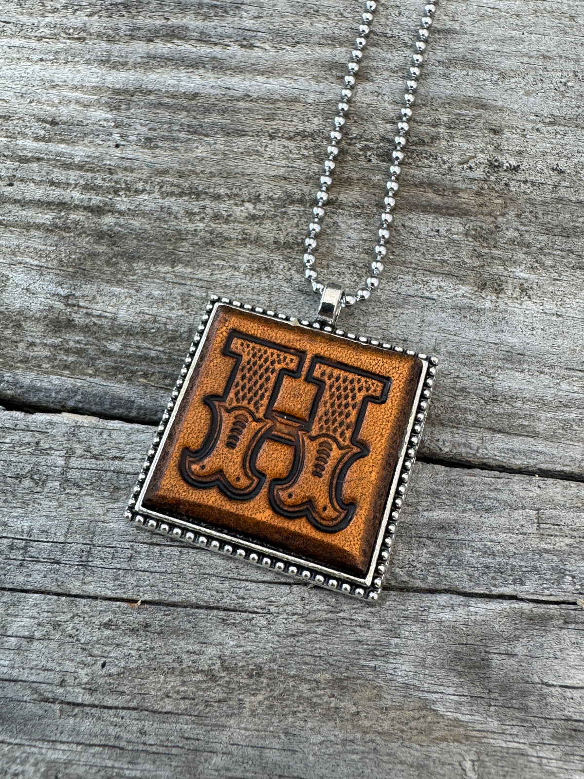 Western Block Letter H leather initial necklace featuring bold decorative cowboy-style lettering in a square silver-tone pendant.