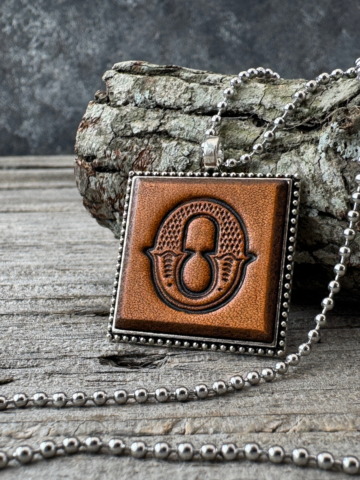 Western Block Letter O leather initial necklace styled on rustic wood