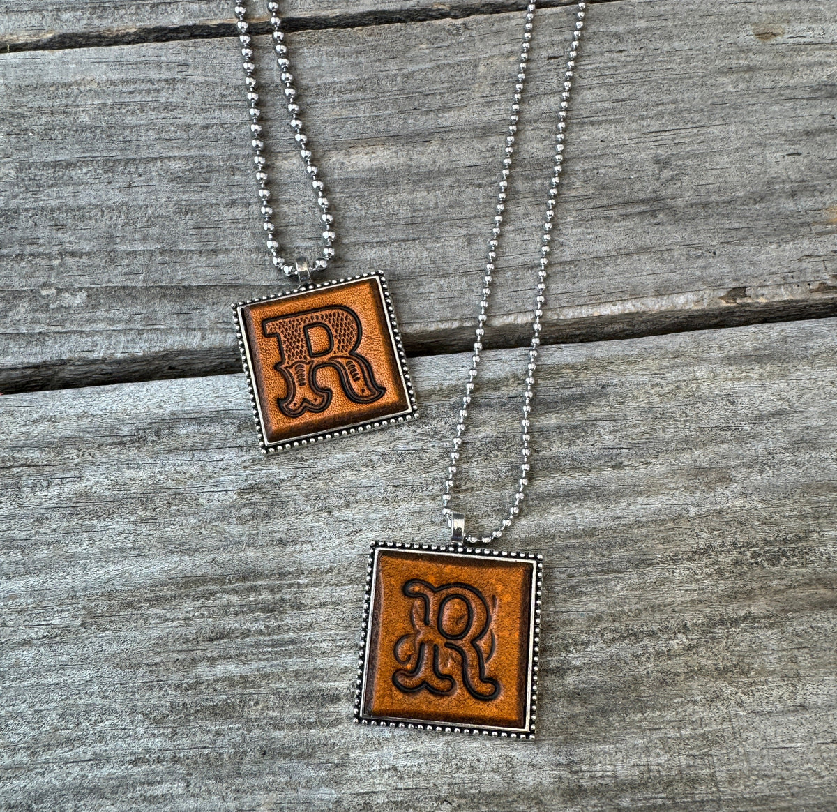 Two handmade Letter R leather initial necklaces in Western Block and Floral Script fonts