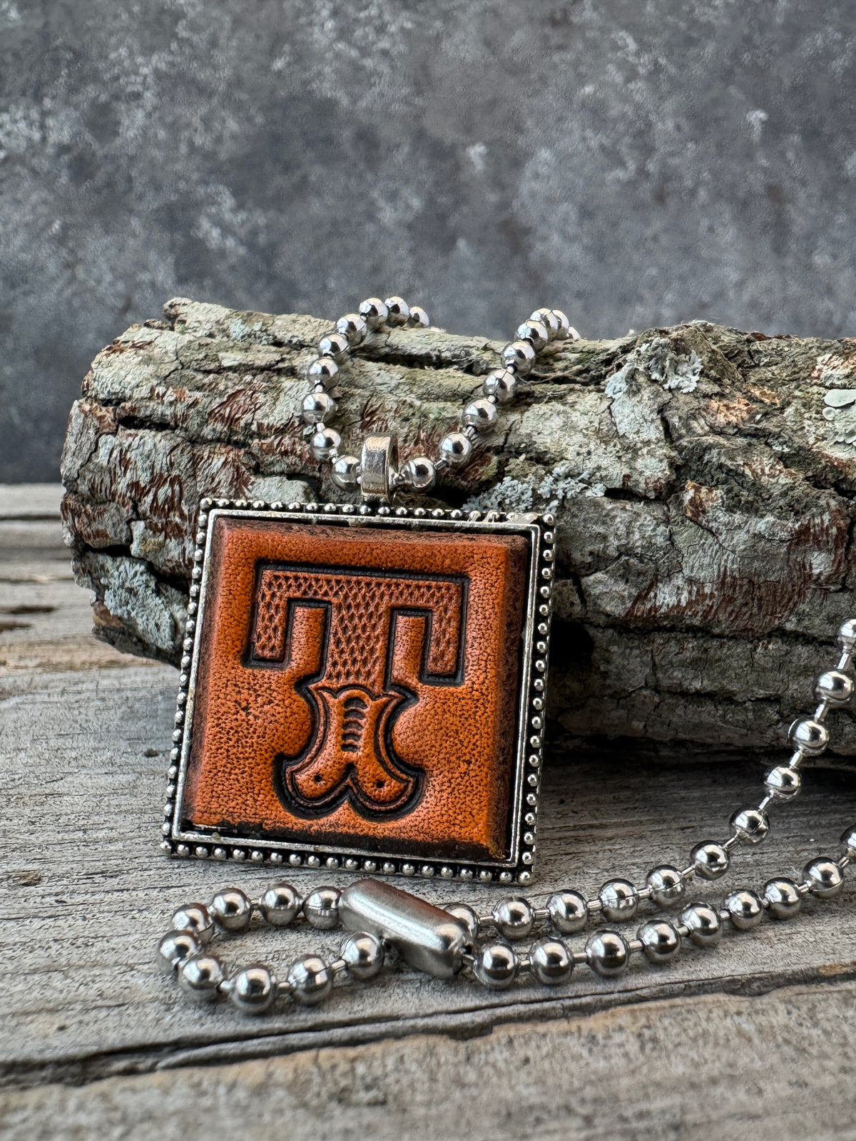 Western Block Letter T leather initial necklace styled on rustic wood