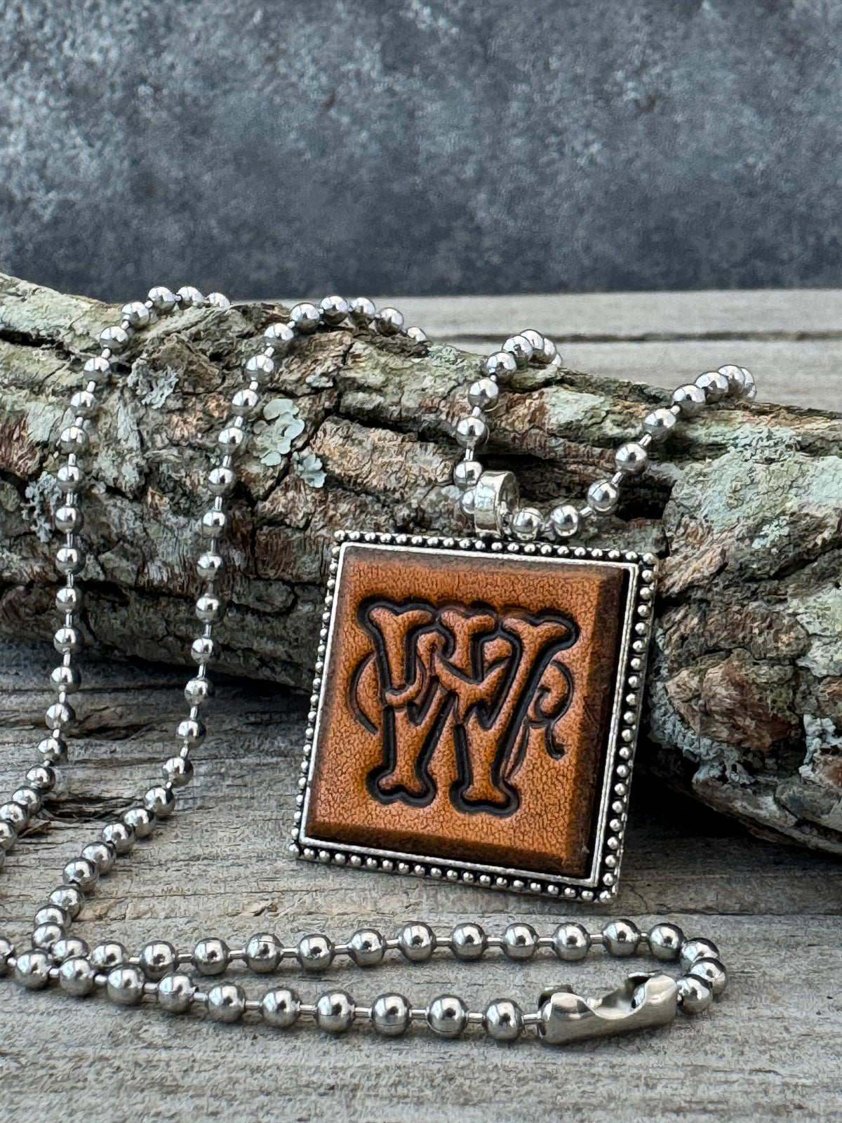 Floral Script Letter W leather initial necklace styled on rustic wood