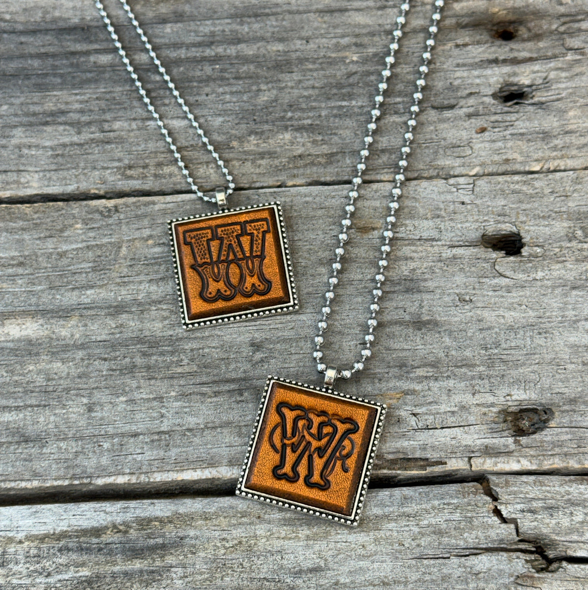 Two handmade Letter W leather initial necklaces in Western Block and Floral Script fonts