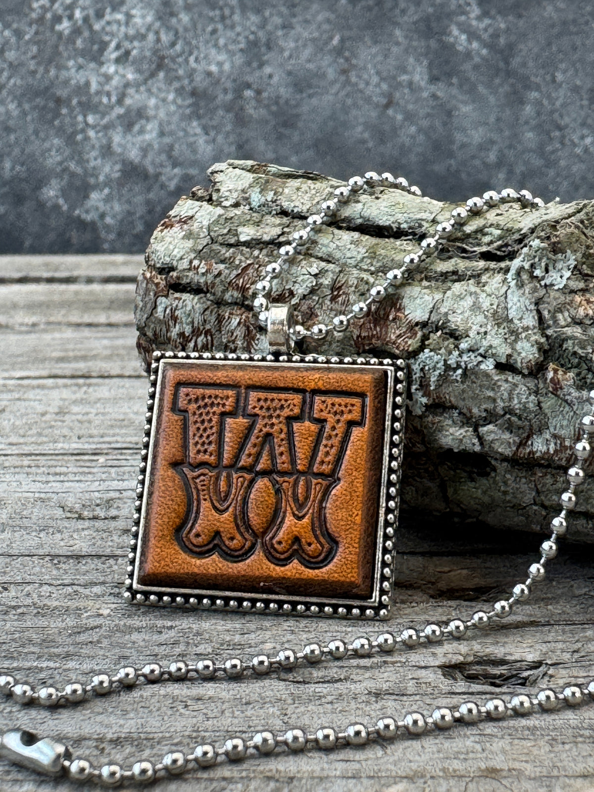 Western Block Letter W leather initial necklace styled against natural wood