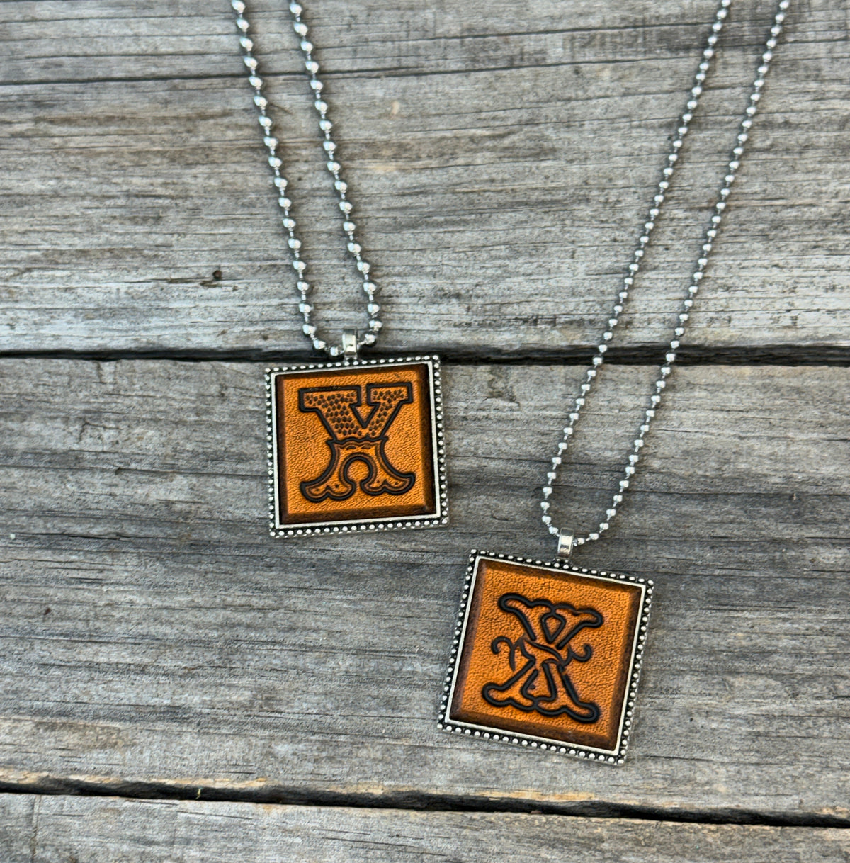 Two handmade Letter X leather initial necklaces in Western Block and Floral Script fonts