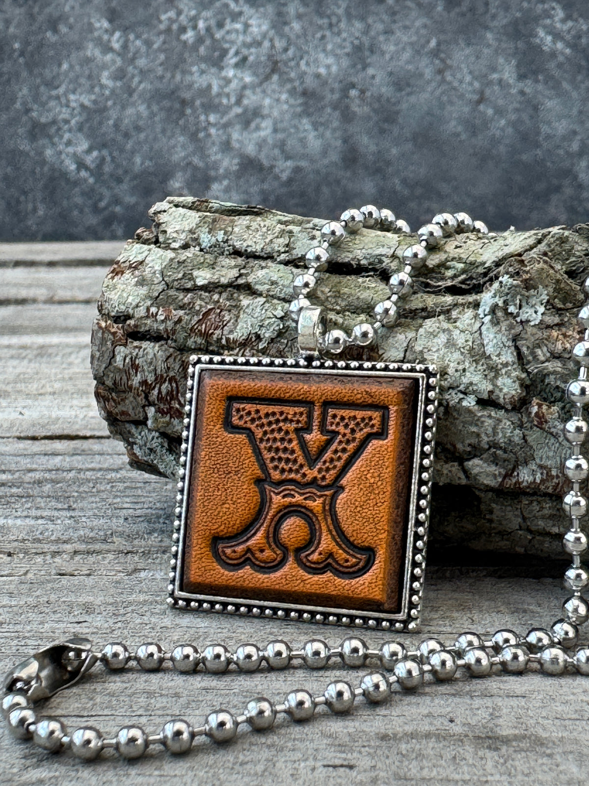 Western Block Letter X leather initial necklace styled on rustic wood