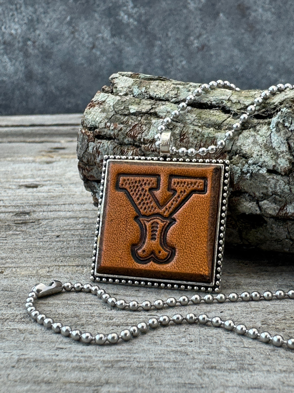 Western Block Letter Y leather initial necklace styled on rustic wood