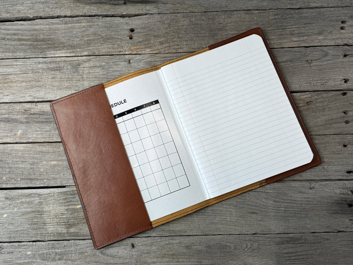 Medium brown leather composition notebook cover open with refillable wide ruled notebook