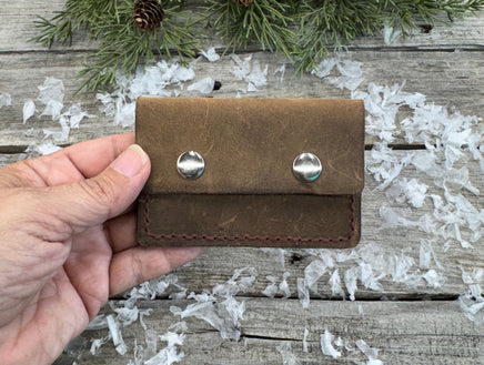 Handmade brown oil-tanned leather card wallet with double snap closure and burgundy stitching, crafted by Cherokee Rose Custom Leather in East Texas.