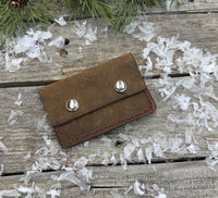 Handmade brown oil-tanned leather card wallet with double snap closure and burgundy stitching, crafted by Cherokee Rose Custom Leather in East Texas.