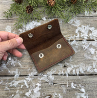 Handmade brown oil-tanned leather card wallet with double snap closure and burgundy stitching, crafted by Cherokee Rose Custom Leather in East Texas.