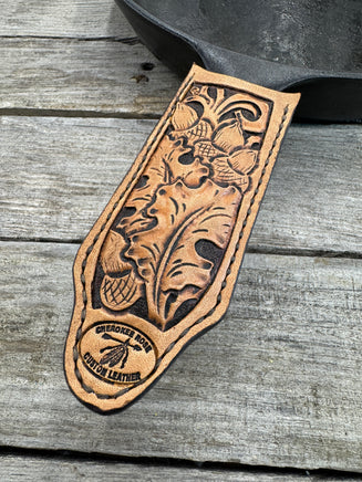 Hand tooled leather cast iron skillet handle cover with oak leaf and acorn carving, light tan dye, handmade by Cherokee Rose Custom Leather in East Texas.