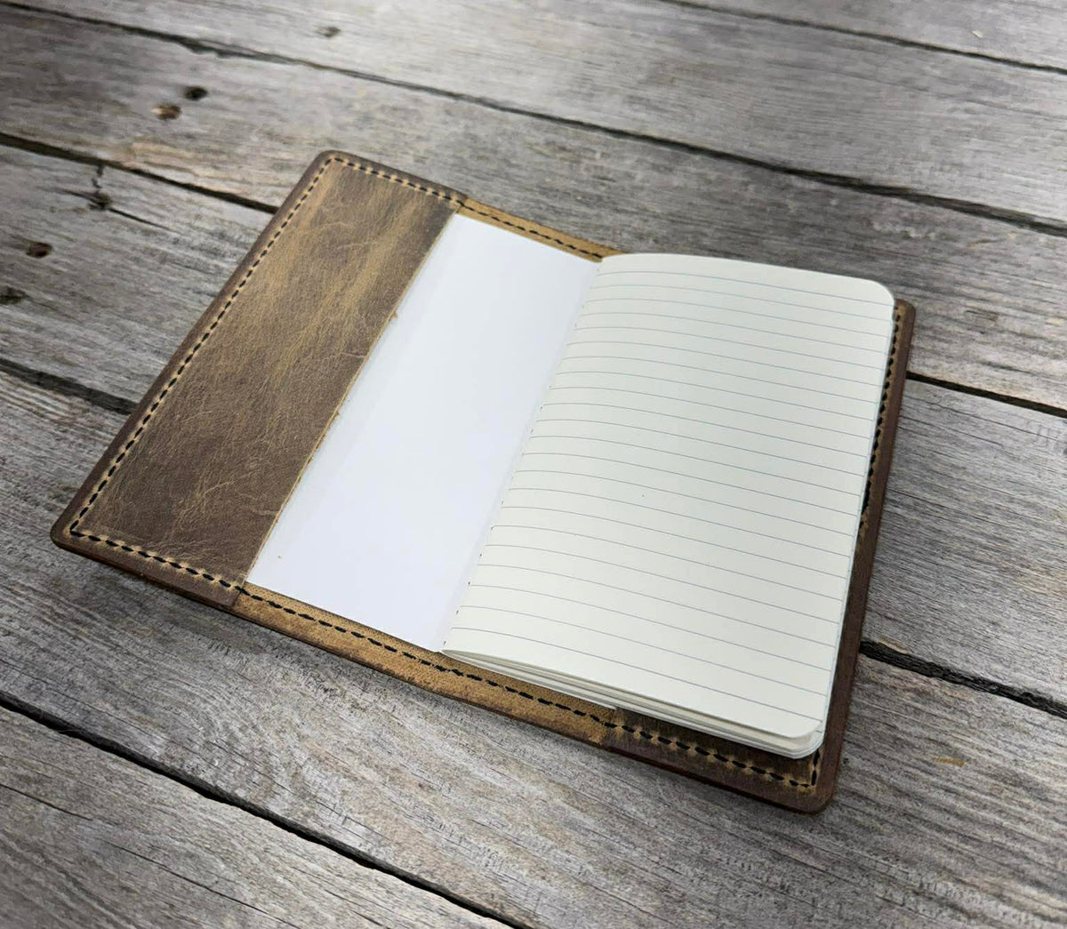 Open notebook with lined pages on a wooden surface