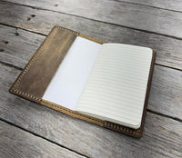Open notebook with lined pages on a wooden surface