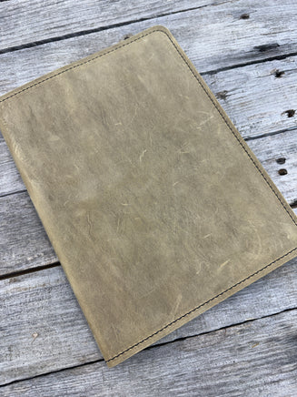 Palomino oil tanned leather composition notebook cover with rustic suede finish and black stitching.