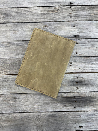 Palomino oil tanned leather composition notebook cover with rustic suede finish and black stitching.