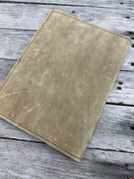 Palomino oil tanned leather composition notebook cover with rustic suede finish and black stitching.