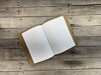 Open notebook with lined pages on a wooden surface