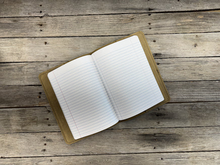Open notebook with lined pages on a wooden surface