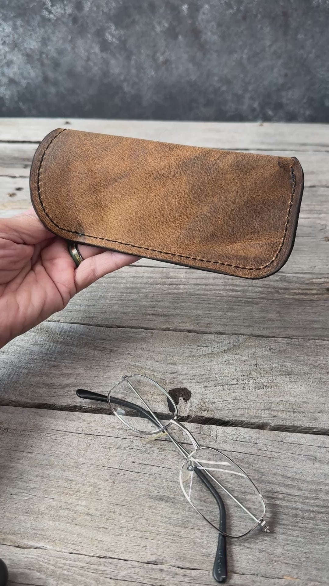 Rustic Brown oil tanned leather eyeglass case shown in hand with exterior details