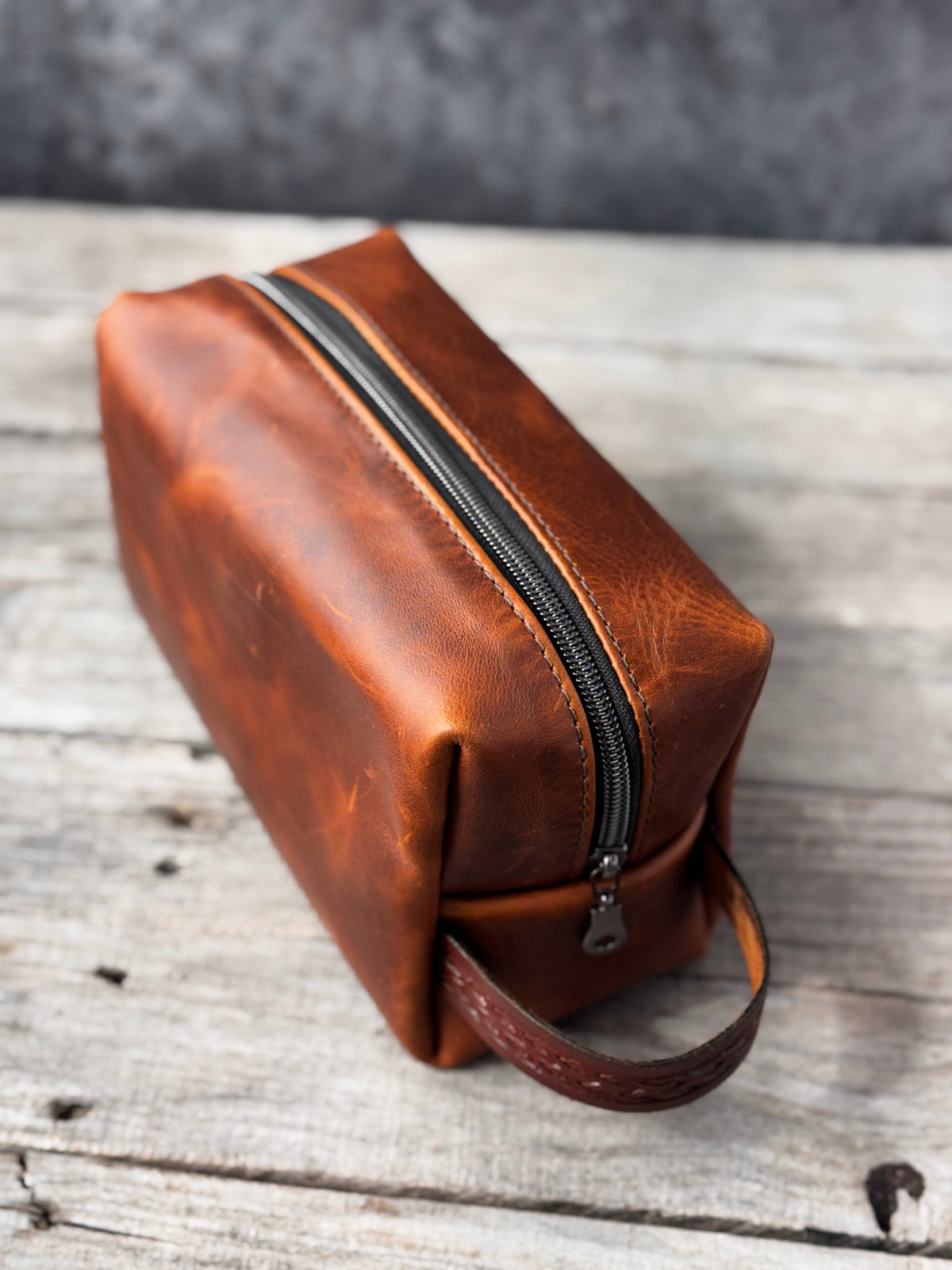 Handmade brown leather Dopp kit from above showing black zipper and structured corners
