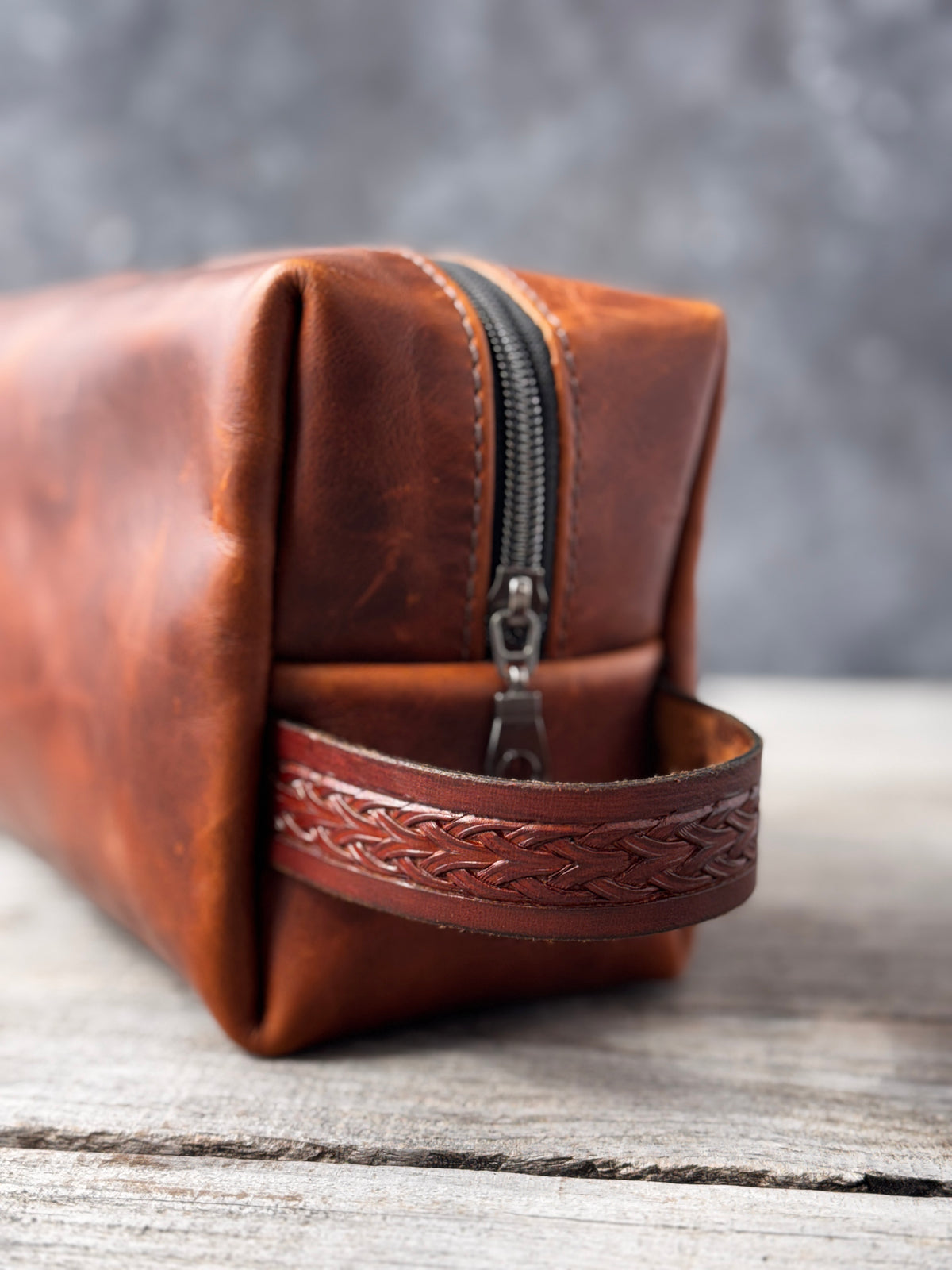Leather Dopp kit end view showing hand-stamped leather carrying handle and black zipper