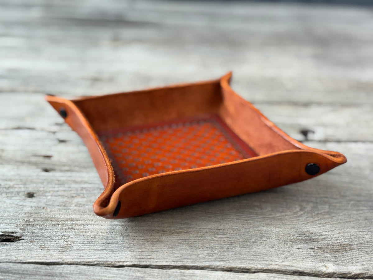 Brown leather tray with diamond pattern on a wooden surface