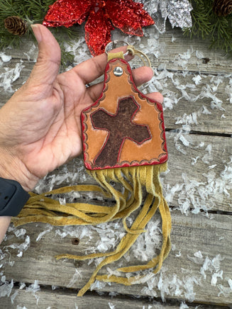 Hand painted leather purse charm in cattle tag shape with red cross design and deerskin fringe by Cherokee Rose Custom Leather in East Texas.