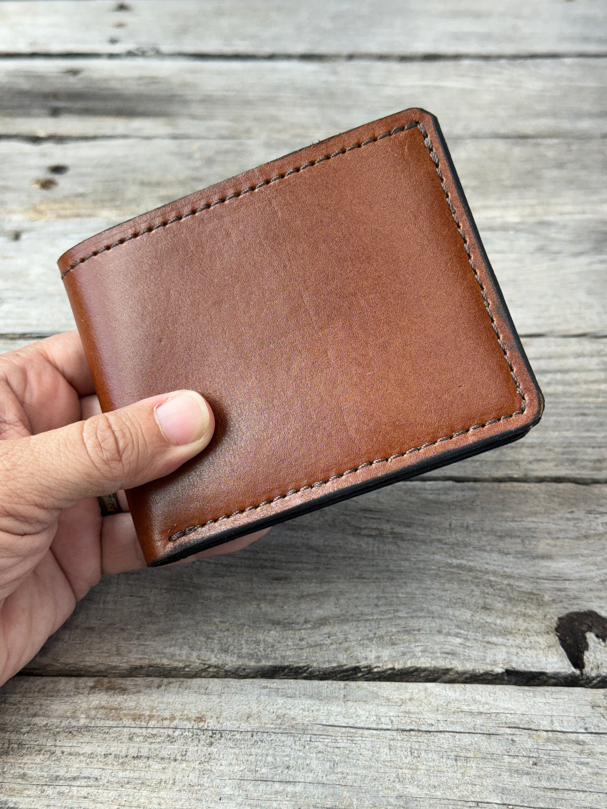 Rodeo Tan oil tanned leather bifold wallet held in hand