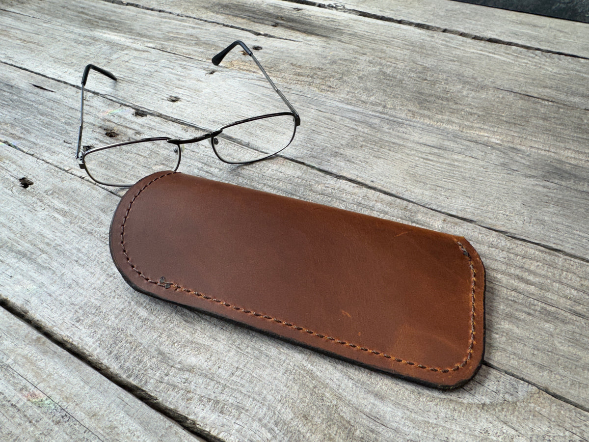Rustic brown oil tanned leather eyeglass case with eyeglasses for size reference