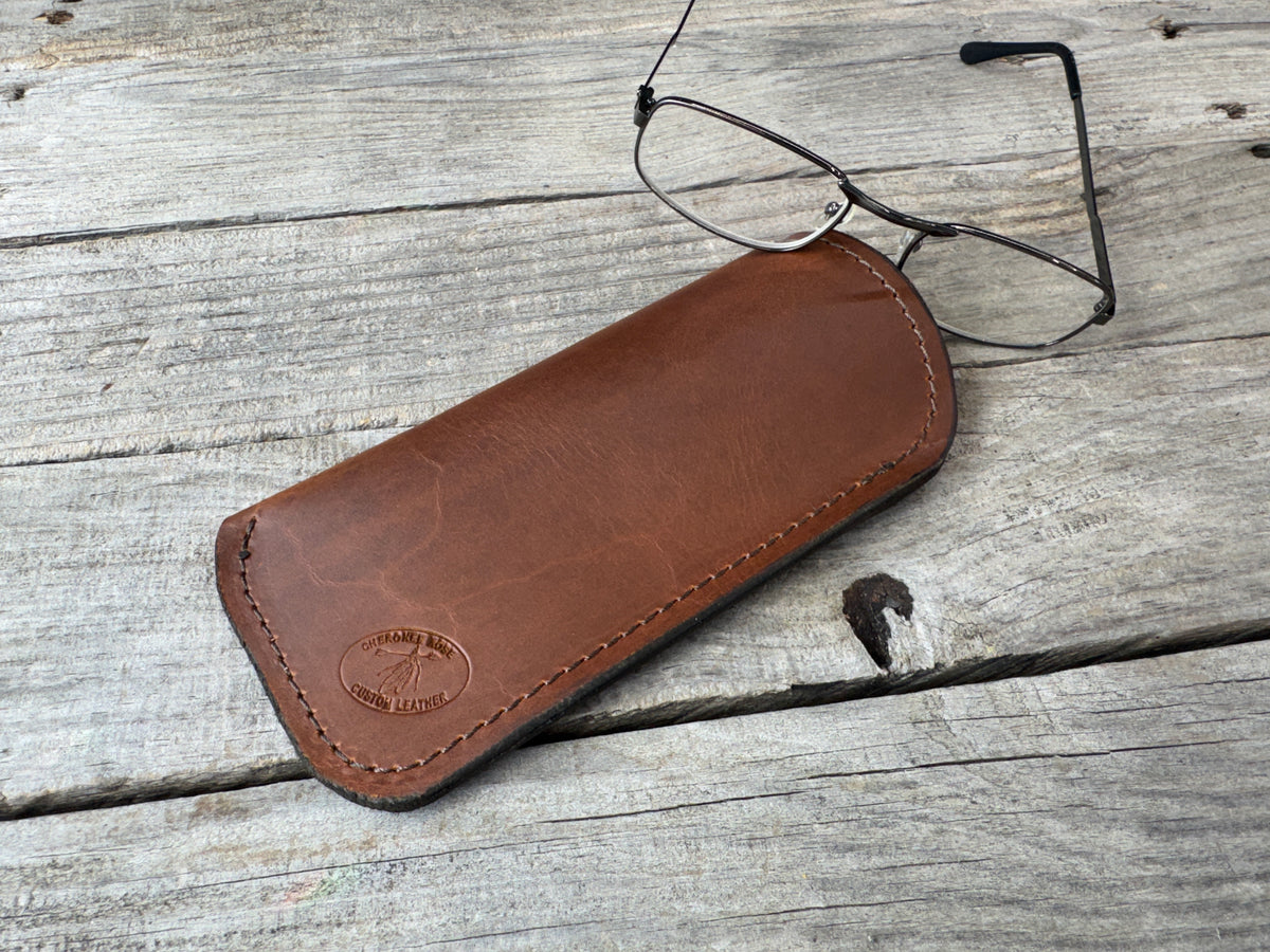 Rustic brown leather eyeglass case showing natural leather grain and black stitching