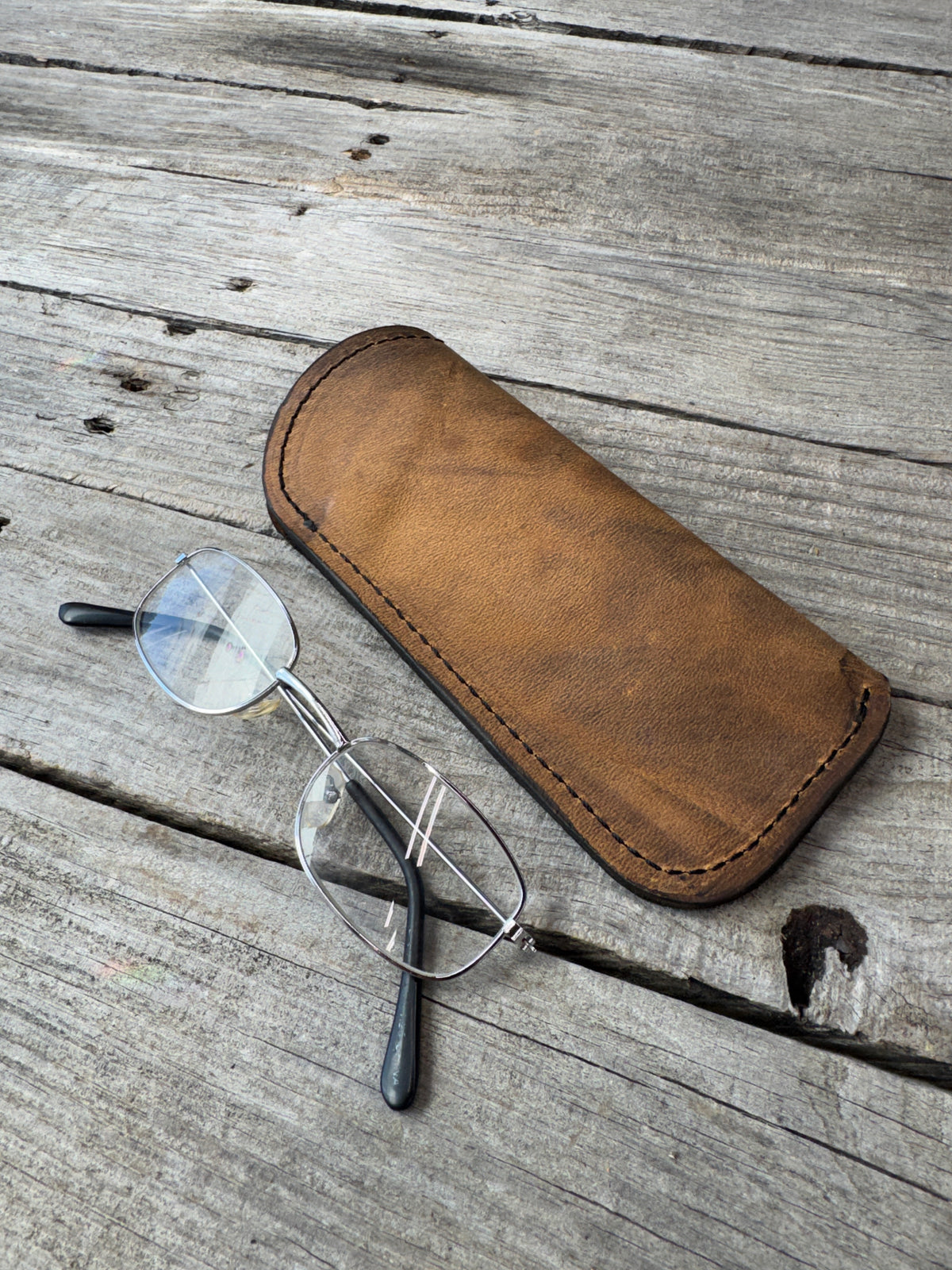 Rustic brown oil tanned leather eyeglass case with eyeglasses for size reference